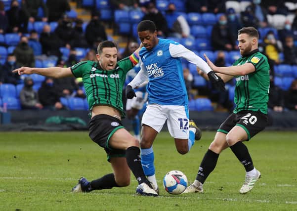 Reece Brown of Peterborough United takes on Eoghan O'Connell and Jimmy Ryan of Rochdale. Photo: Joe Dent/theposh.com.