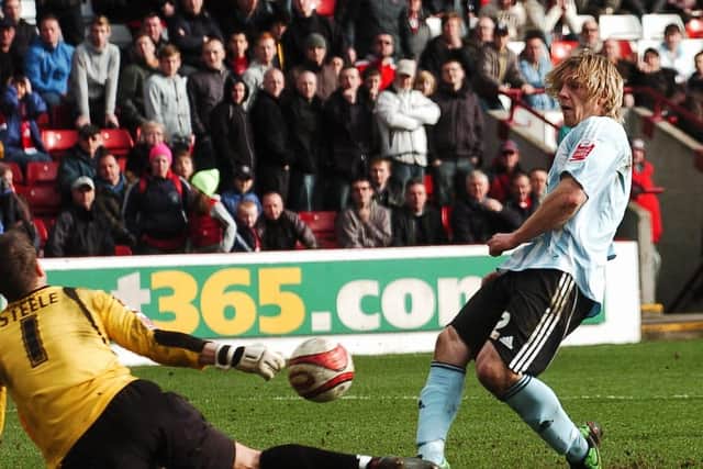 Luke Steele, playing for Barnsley, smothers a shot from Posh star Craig Mackail-Smith.