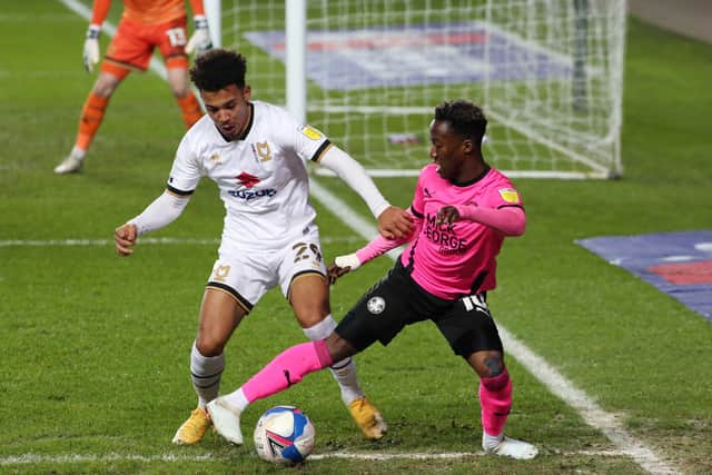 Siriki Dembele of Peterborough United in action with Matthew Sorinola of Milton Keynes Dons. Photo: Joe Dent/theposh.com.