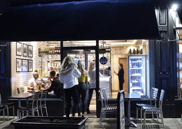 Diners queue to enter the Pizza House in Cowgate. Pictures: David Lowndes