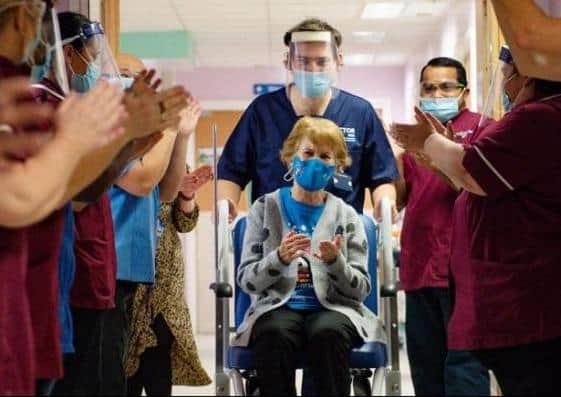 Medical staff cheer as Margaret Keenan gets the first vaccine.