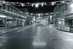 A pre-pedestrianised Bridge Street illuminated by festive decorations.