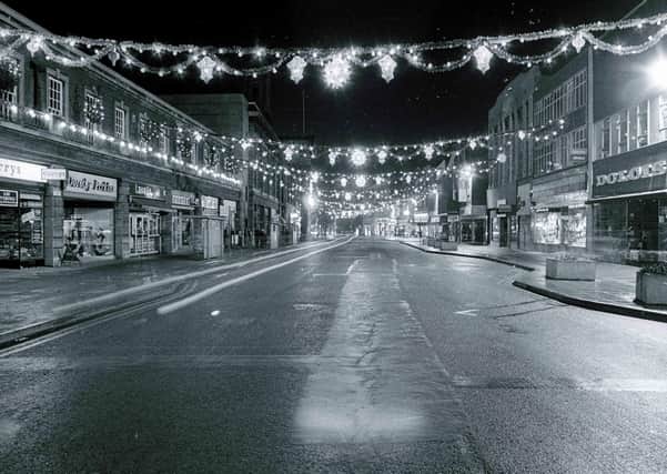 A pre-pedestrianised Bridge Street illuminated by festive decorations.