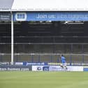 Posh player Serhat Tasdemir warns up in front of an empty London Road terrace. Photo: David Lowndes.