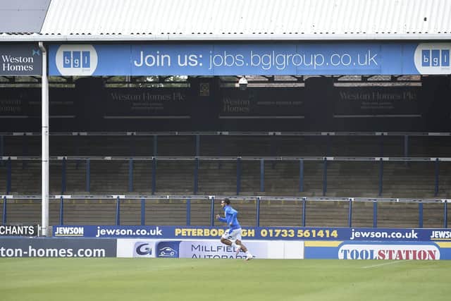 Posh player Serhat Tasdemir warns up in front of an empty London Road terrace. Photo: David Lowndes.