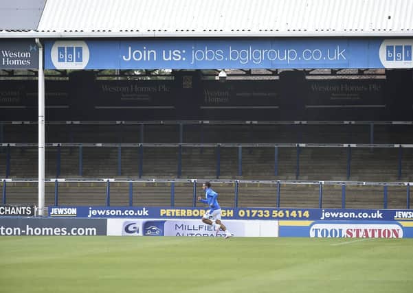 Posh player Serhat Tasdemir warns up in front of an empty London Road terrace. Photo: David Lowndes.