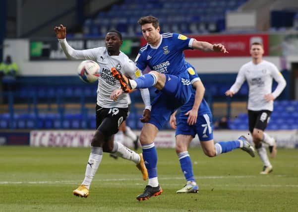 Idris Kanu of Peterborough United battles with Stephen Ward of Ipswich Town. Photo: Joe Dent/theposh.com.