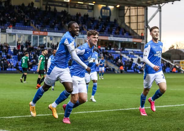 Harrison Burrows (centre) and Flynn Clarke (right) celebrate a Posh goal against Rochdale with Idris Kanu.