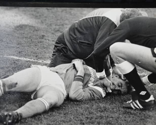 Posh full-back Steve Collins lies stricken on the pitch during a game against Northampton.