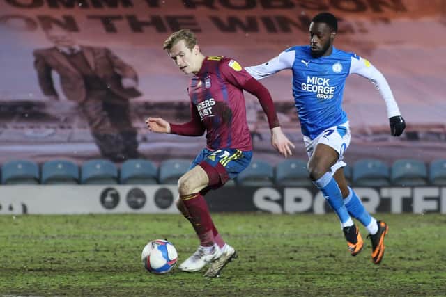 Mohamed Eisa of Peterborough United puts pressure on Flynn Downes of Ipswich Town. Photo: Joe Dent/theposh.com.