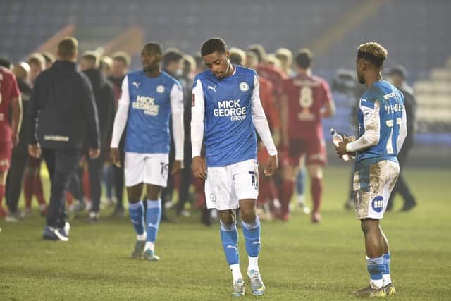 Posh players are dejected while Chorley players celebrate a famous FA Cup win. Photo: Joe Dent/theposh.com.