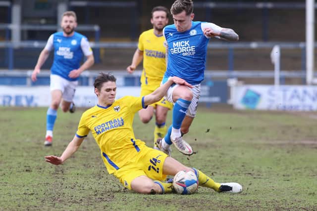 Sammie Szmodics of Peterborough United is tackled by George Dobson of AFC Wimbledon. Photo: Joe Dent/theposh.com.