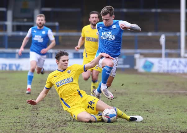 Sammie Szmodics of Peterborough United is tackled by George Dobson of AFC Wimbledon. Photo: Joe Dent/theposh.com.