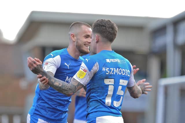 Joe Ward helps Sammie Szmodics celebrate his second goal for Posh against AFC Wimbledon. Photo: David Lowndes.