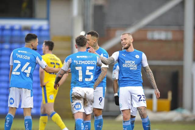 Posh players celebrate the final goal against AFC Wimbledon. Photo: David Lowndes.