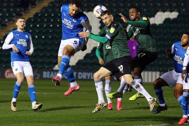Jonson Clarke-Harris of Peterborough United challenges for the ball with Danny Mayor of Plymouth Argyle. Photo: Joe Dent/theposh.com.