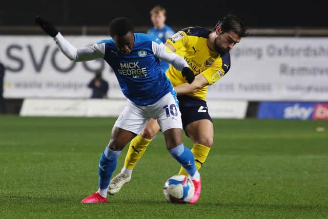 Siriki Dembele of Peterborough United battles with Elliott Lee of Oxford United. Photo: Joe Dent/theposh.com.