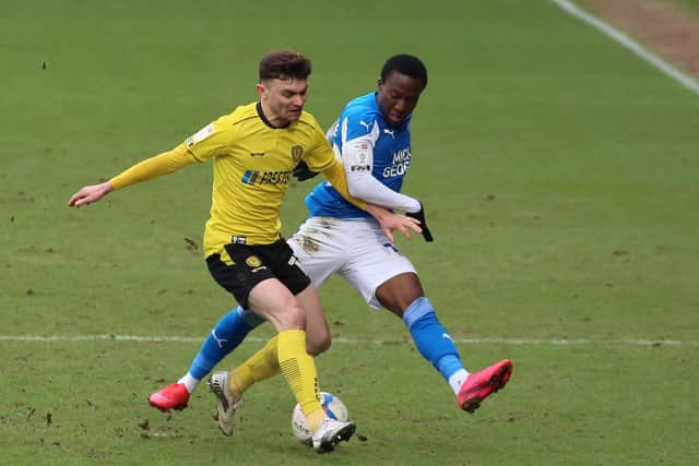 Siriki Dembele of Peterborough United puts pressure on Jonny Smith of Burton Albion. Photo: Joe Dent/theposh.com.