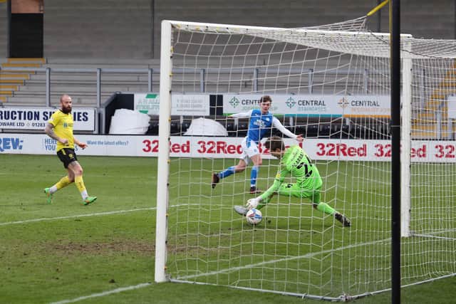 Harrison Burrows of Peterborough United scores past Ben Garratt of Burton Albion on Saturday. Photo: Joe Dent/theposh.com.