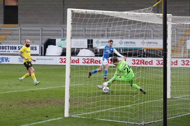 Harrison Burrows of Peterborough United scores past Ben Garratt of Burton Albion on Saturday. Photo: Joe Dent/theposh.com.