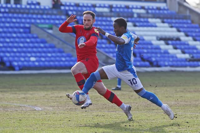 Siriki Dembele of Peterborough United in action with Dan Gardner of Wigan Athletic. Photo: Joe Dent/theposh.com.