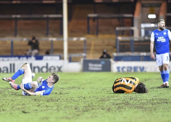 Posh midfielder Ethan Hamilton (right) has just clattered into Lewie Coyle of Hull, a challenge that would lead to a red card. Photo: David Lowndes.