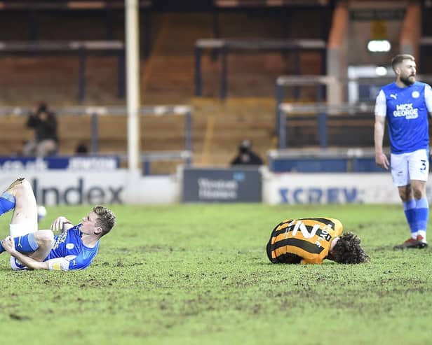Posh midfielder Ethan Hamilton (right) has just clattered into Lewie Coyle of Hull, a challenge that would lead to a red card. Photo: David Lowndes.
