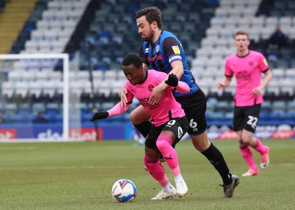 Siriki Dembele of Peterborough United is held back by Eoghan O'Connell of Rochdale. Photo: Joe Dent/theposh.com.