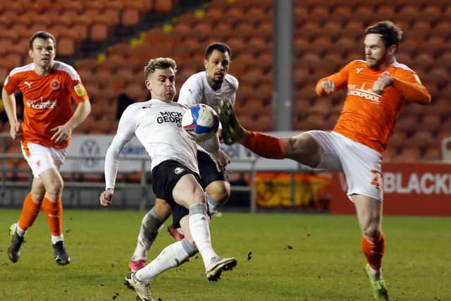 Sammie Szmodics of Peterborough United in action with Oliver Turton of Blackpool. Photo; Joe Dent/theposh.com.