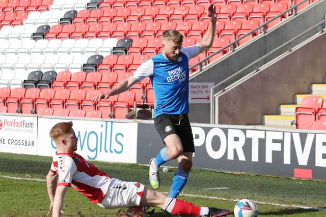 Dan Butler of Peterborough United is tackled by Callum Camps of Fleetwood Town. Photo: Joe Dent/theposh.com.