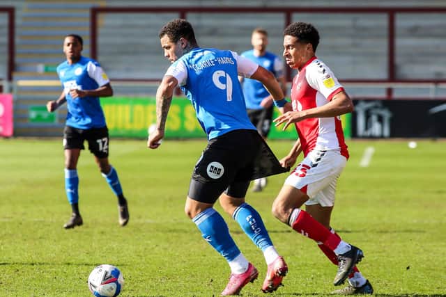 Jonson Clarke-Harris has his shorts pulled back by James Hill of Fleetwood Town. Photo: Joe Dent/theposh.com.