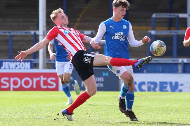 Harrison Burrows of Peterborough United in action with Carl Winchester of Sunderland. Photo: Joe Dent/theposh.com.