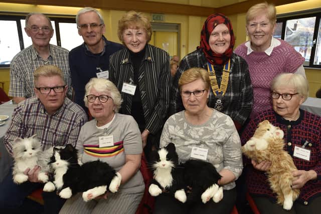 Dementia patients and carers at the Crocus Cafe with Aasiyah Joseph, president of Peterborough Rotary Club, and the robotic cats presented by Rotary to the café