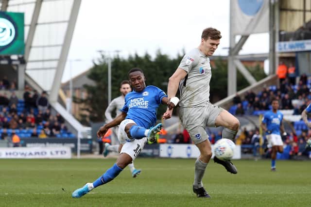 Siriki Dembele of Peterborough United in action with Sean Raggett of Portsmouth. Photo: Joe Dent/theposh.com.