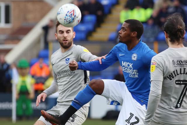 Reece Brown of Peterborough United in action with Ben Close of Portsmouth.