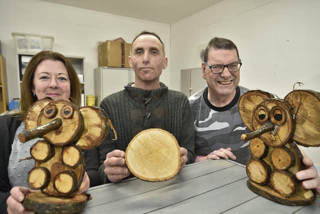 City College Day Opportunities Industrial Hub at Hampton. Co-ordinator Sarah Lewis with supported people  Stephen Barry and Lawrence Cope with their woodwork elephants. EMN-200203-164818009