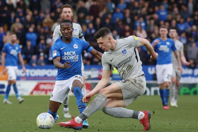 Siriki Dembele of Peterborough United in action with James Bolton of Portsmouth. Photo: Joe Dent/theposh.com.