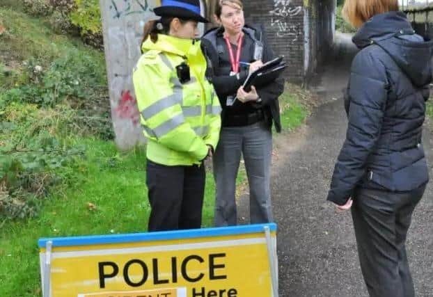 Police officers putting out notices and talking to passers-by on a walkway between Rhubarb Bridge at North Bretton