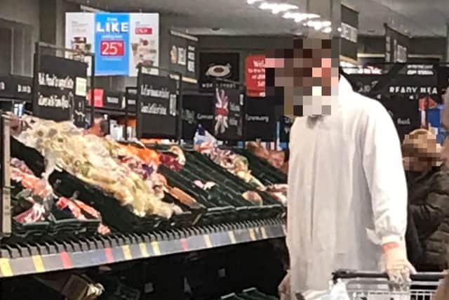 A shopper at Aldi in Maskew Avenue doing their shop in a protective body suit