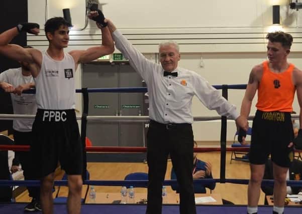 Peterborough Police Boxing Club’s Jaan’sher Raja (left) is declared the winner over Tommy Petchell (right) by referee Frank Allen.