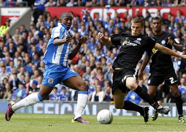 Ryan Bennett tackles Huddersfield's Benik Afobe in the 2011 League One play-off final at Old Trafford.