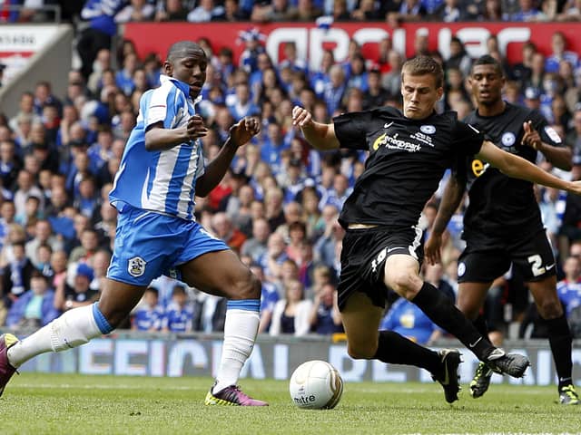 Ryan Bennett tackles Huddersfield's Benik Afobe in the 2011 League One play-off final at Old Trafford.