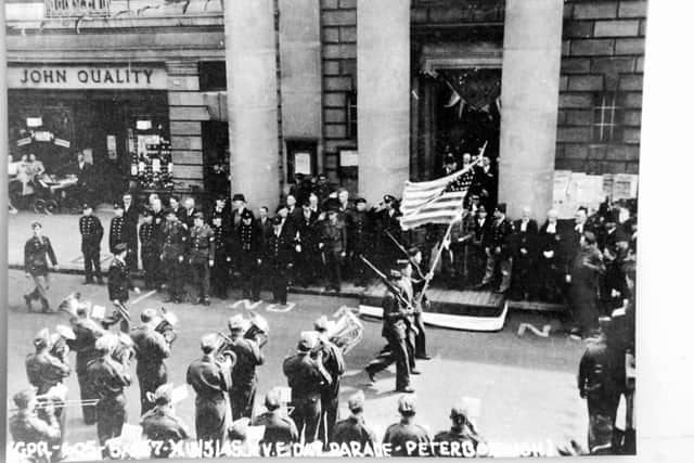 Soldiers marching past the town hall during the VE parade