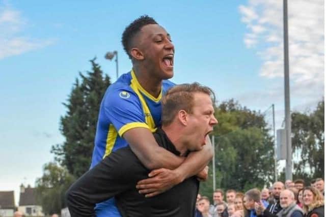 Peterborough Sports boss Jimmy Dean carries star player Dion Sembie-Ferris.