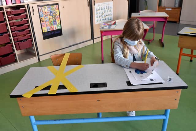 A pupil of the Sainte-Croix elementary school works as half of her writing desk is marked with a tape to ensure that safe distance is kept. (Photo by JOHN THYS / AFP) (Photo by JOHN THYS/AFP via Getty Images) YPN-200515-155813060