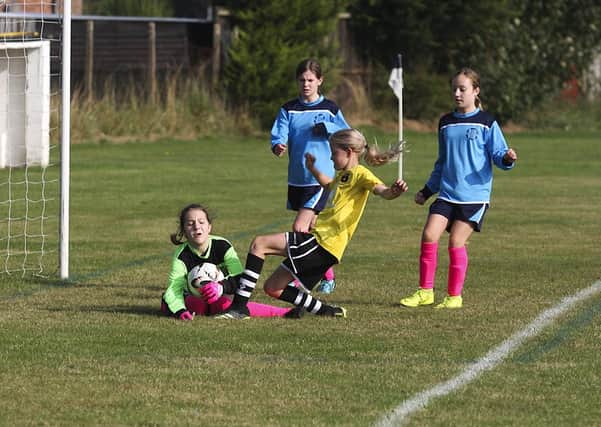 Kate Conkey of Peterborough Northern Star Under 12s challenges the Melbourn goalkeeper. Photo: Tum Symonds.