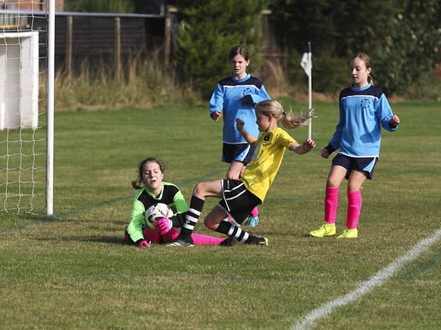 Kate Conkey of Peterborough Northern Star Under 12s challenges the Melbourn goalkeeper. Photo: Tum Symonds.