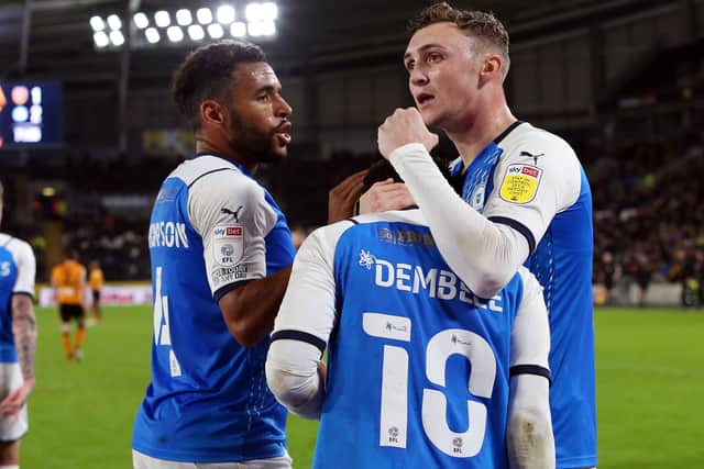 Siriki Dembele of Peterborough United is congratulated by team-mates Nathan Thompson and Jack Taylor after scoring the winning goal at Hull City. Photo: Joe Dent/theposh.com