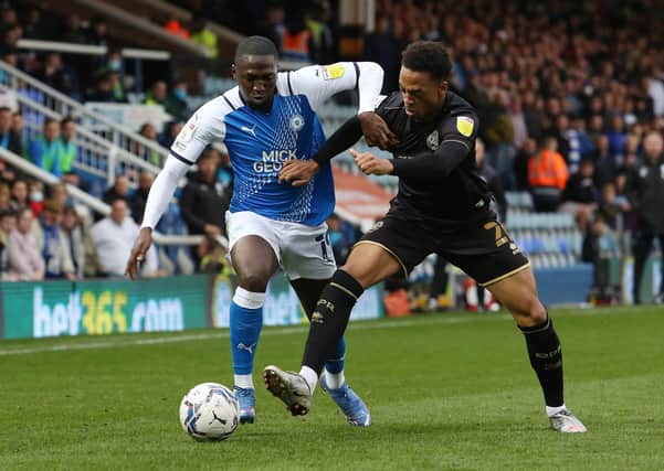 Idris Kanu of Peterborough United battles with Chris Willock of Queens Park Rangers. Photo: Joe Dent/theposh.com.