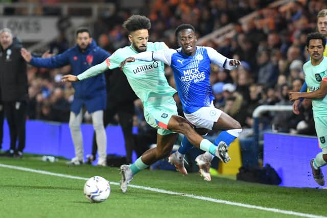 Posh star Sirki Dembele is scythed down by Sorba Thomas of Huddersfield. Photo: David Lowndes.